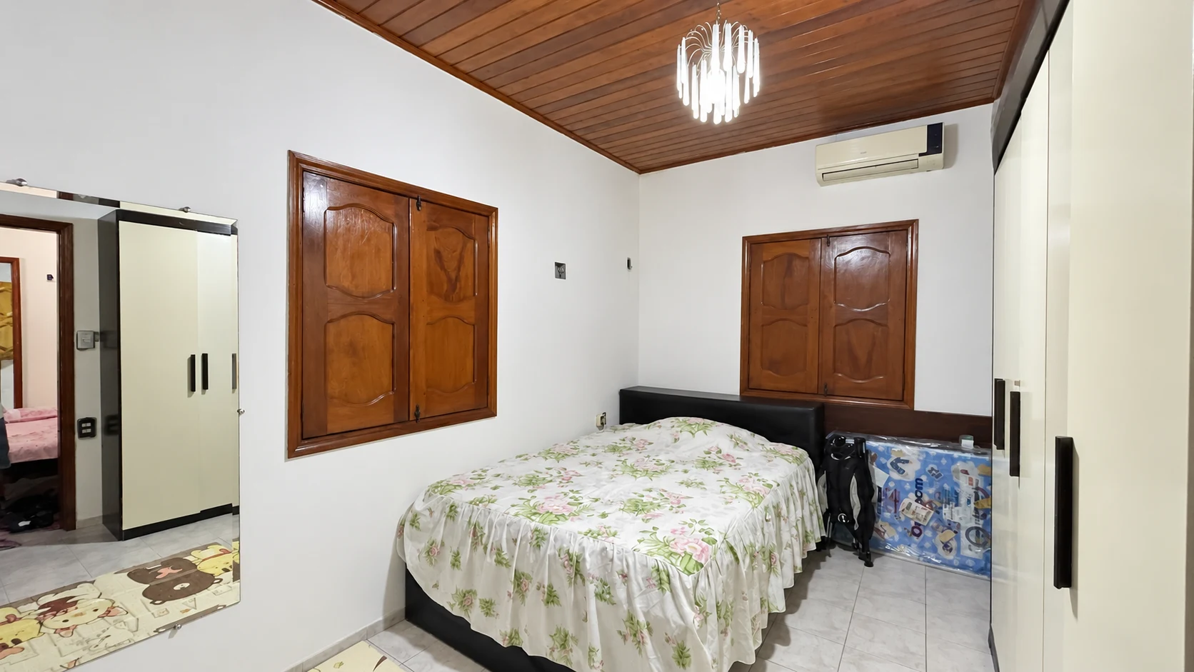Quarto da casa com cama de casal, armários e ar-condicionado